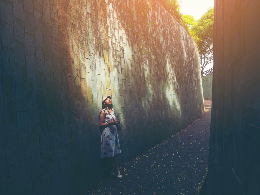 Woman leaning on a wall, looking at the sky