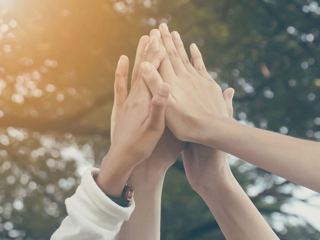 Hands high-fiving as in team work
