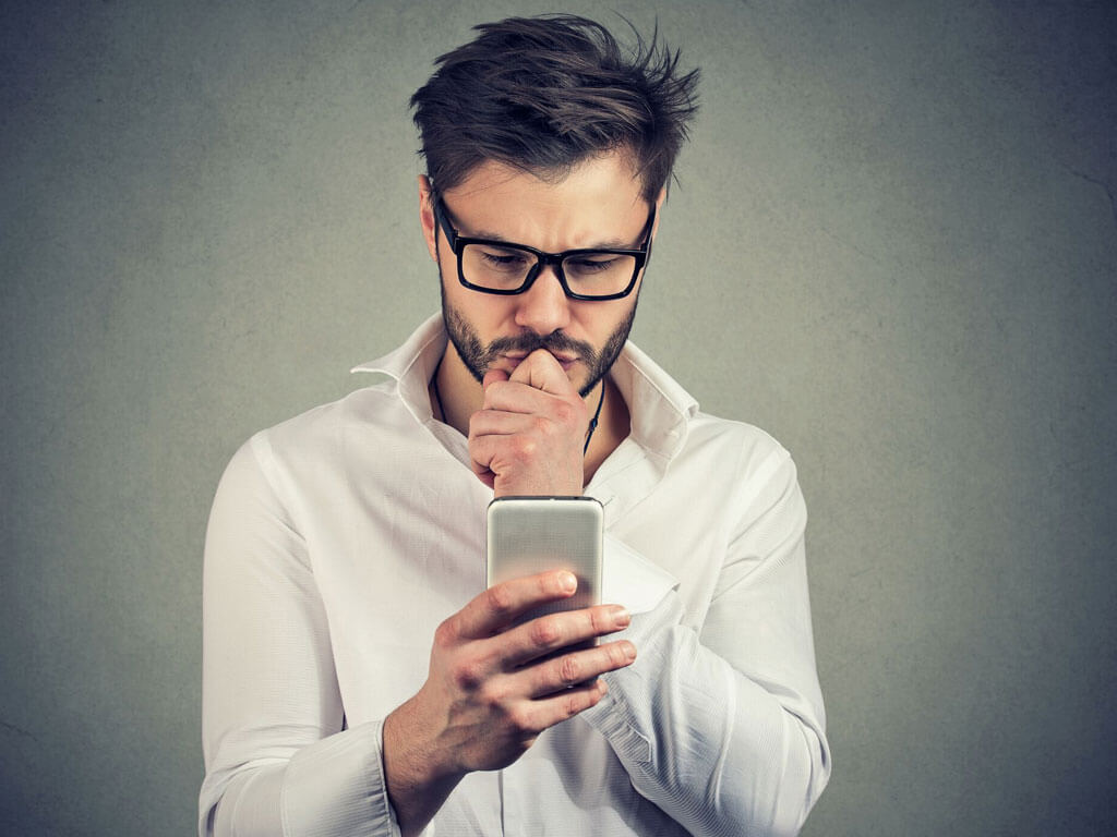 Man looking serious at a smartphone