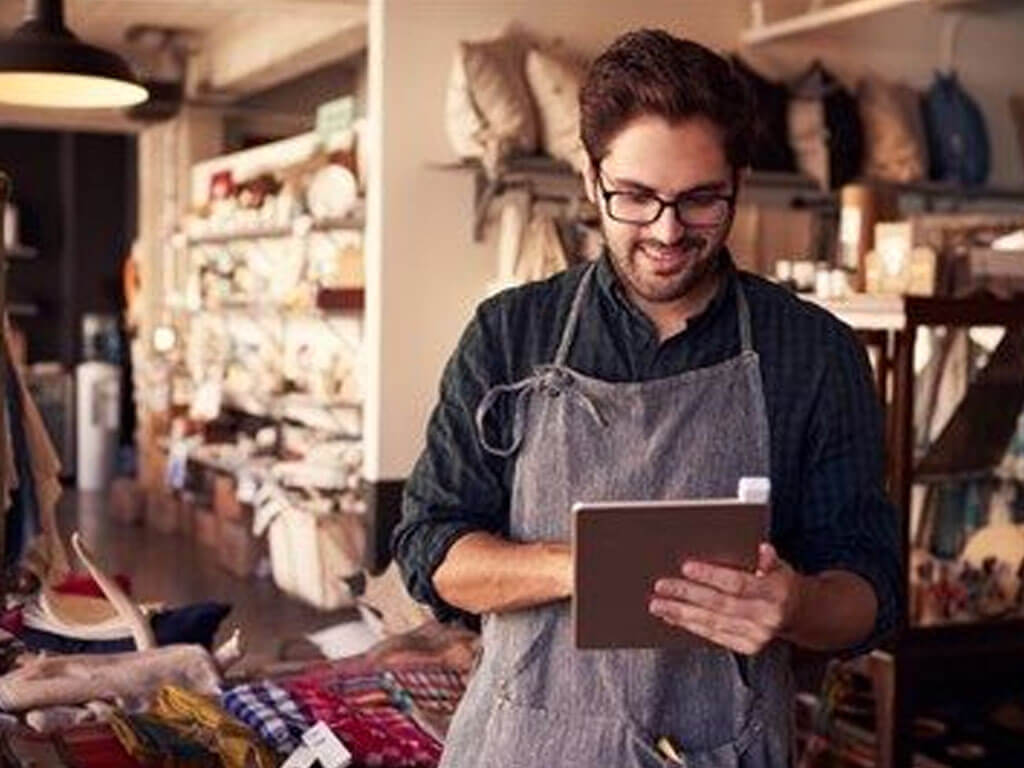 Small store owner holding a laptop