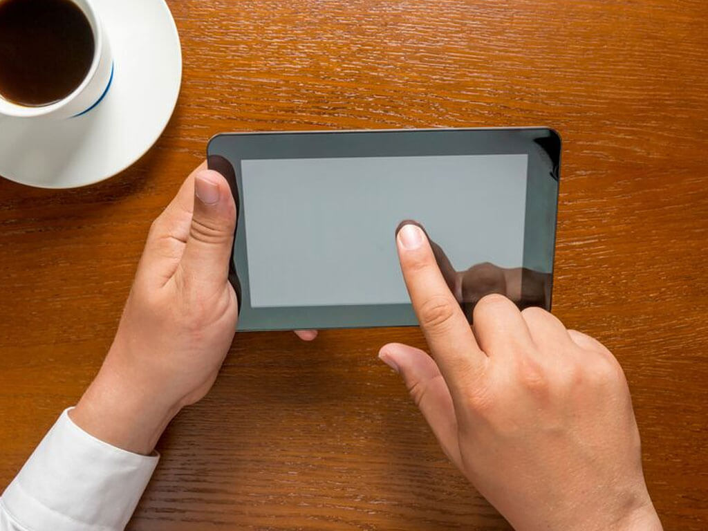Hands holding a small tablet