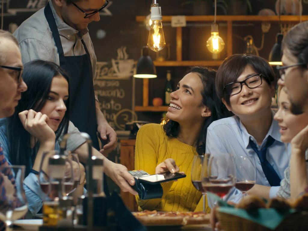 Woman paying a restaurant bill with a smartphone