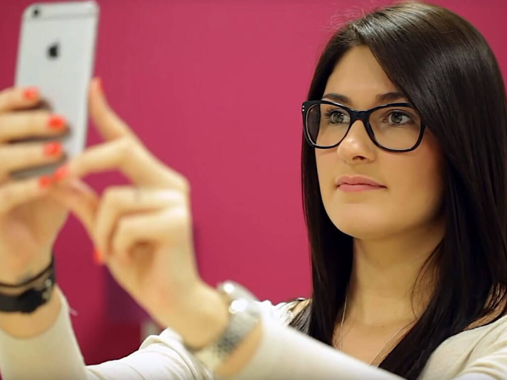 Young woman holding up an iPhone