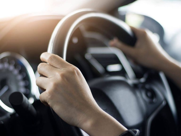 Hands on a steering wheel.