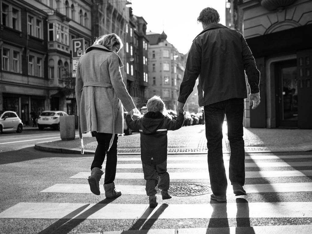Parents walking and holding a child's hands