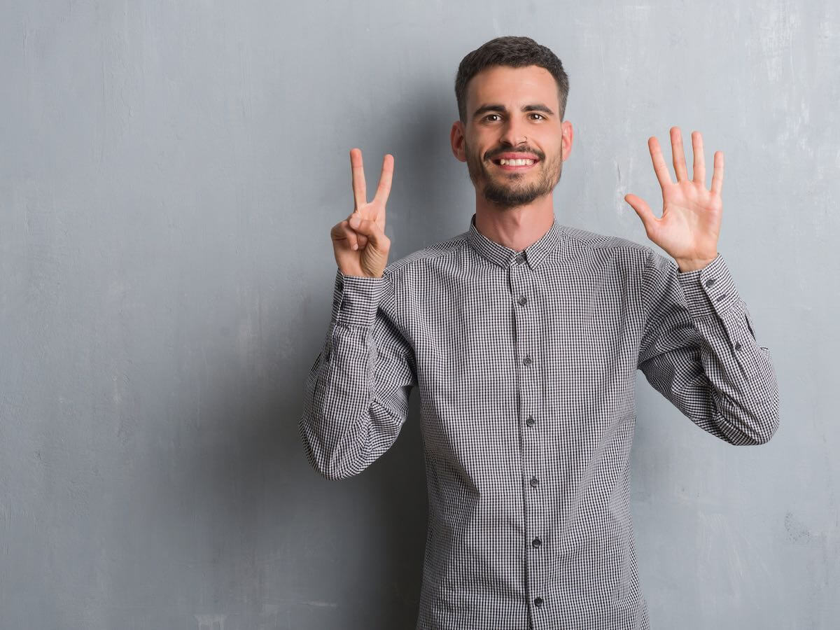 Man holding hands up with 7 fingers open