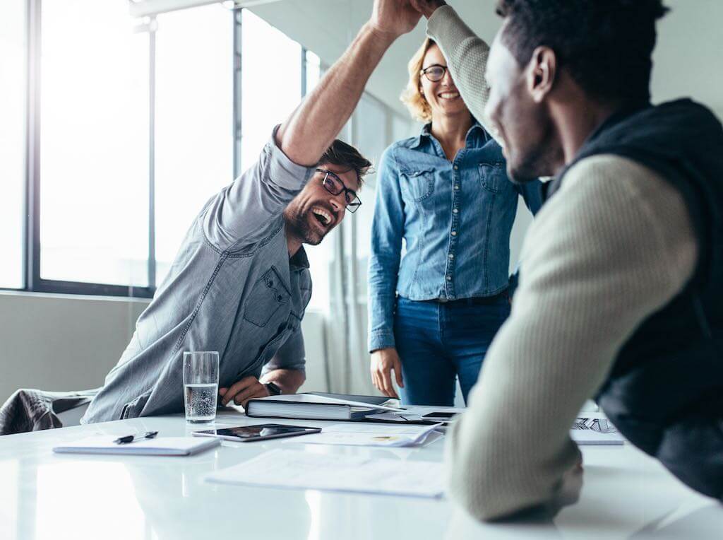 People high-fiving at a meeting