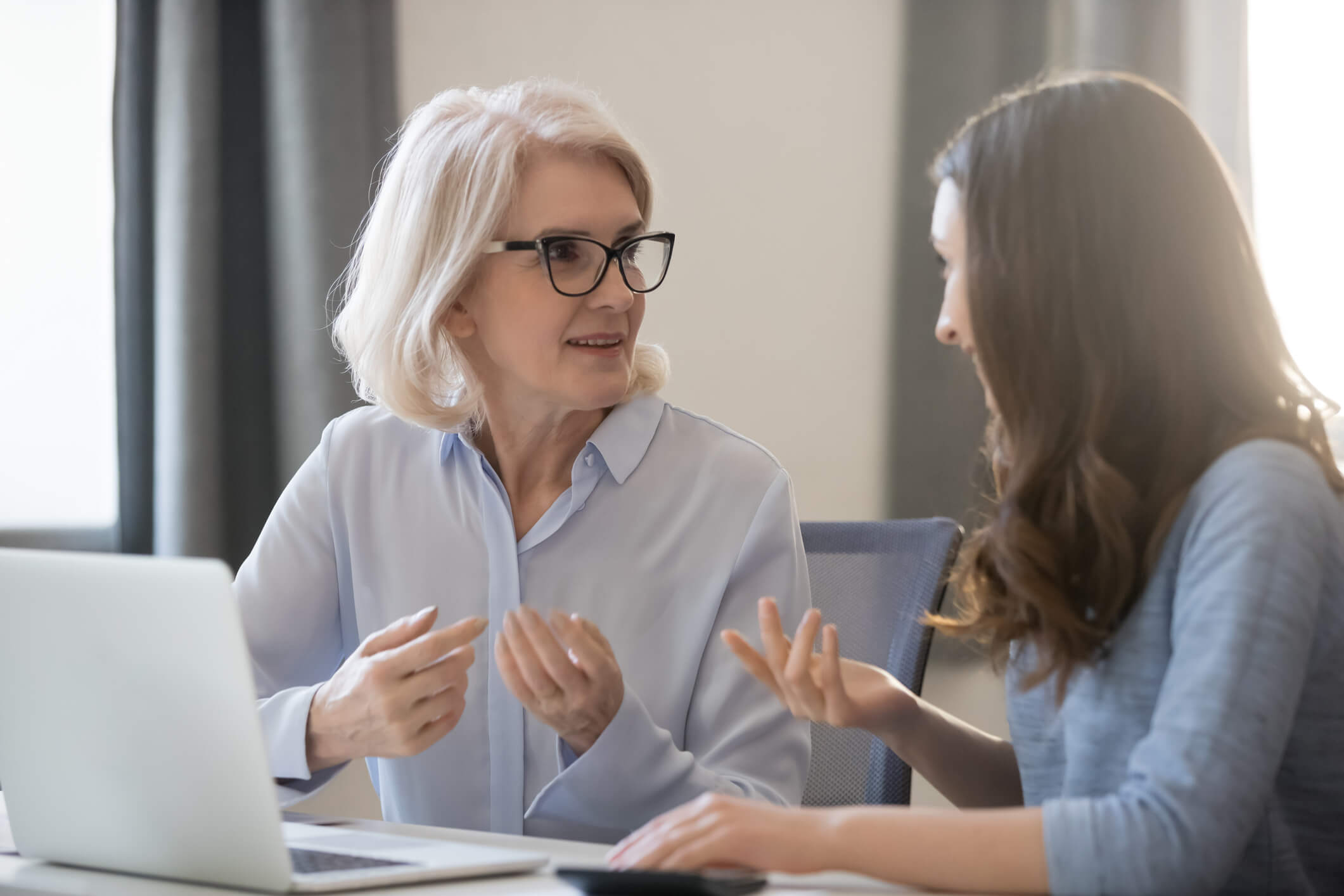 Young daughter helping older mum use digital banking channel